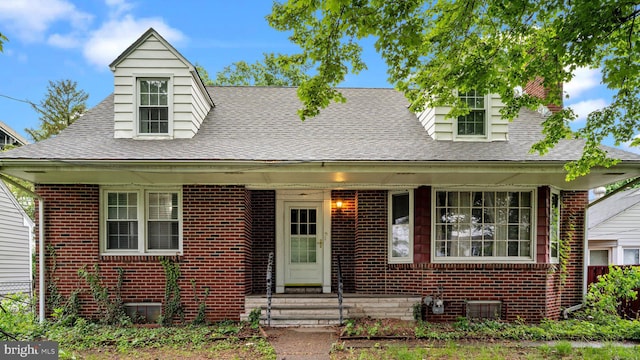 view of front of home featuring roof with shingles and brick siding