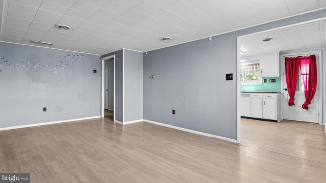 unfurnished living room with light wood finished floors and baseboards