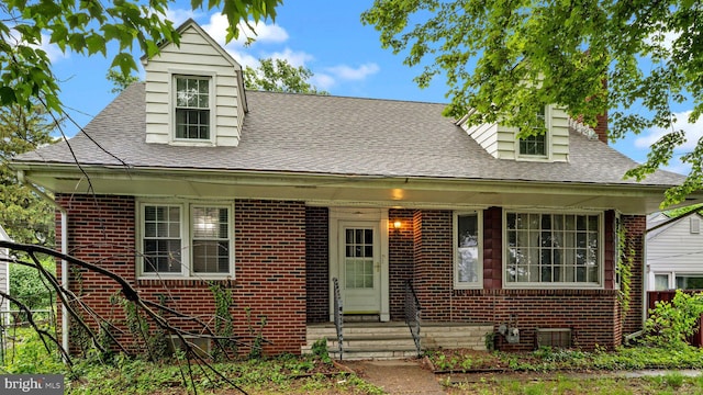 view of front facade featuring a shingled roof and brick siding