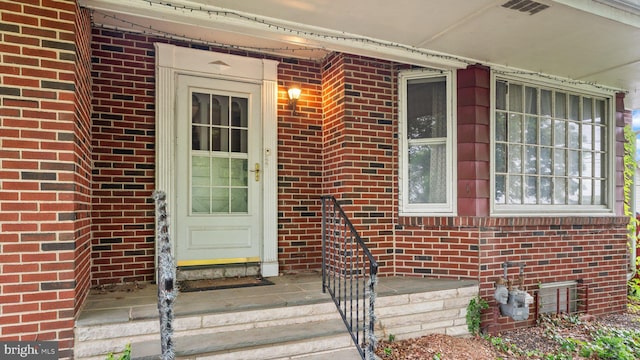 doorway to property featuring brick siding