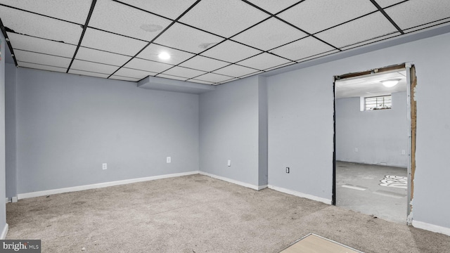 carpeted empty room featuring baseboards and a paneled ceiling