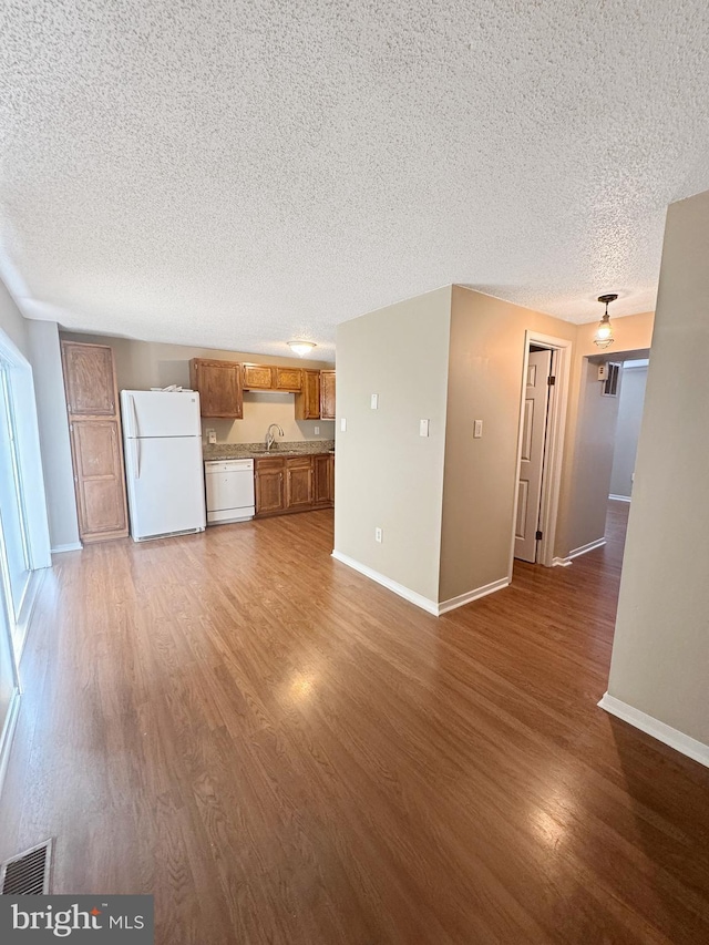 7 E Hart St, Winchester, VA 22601 - unfurnished living room featuring a textured ceiling, a sink, dark wood finished floors, and baseboards