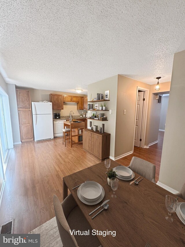 7 E Hart St, Winchester, VA 22601 - dining area featuring a textured ceiling, light wood-type flooring, and baseboards