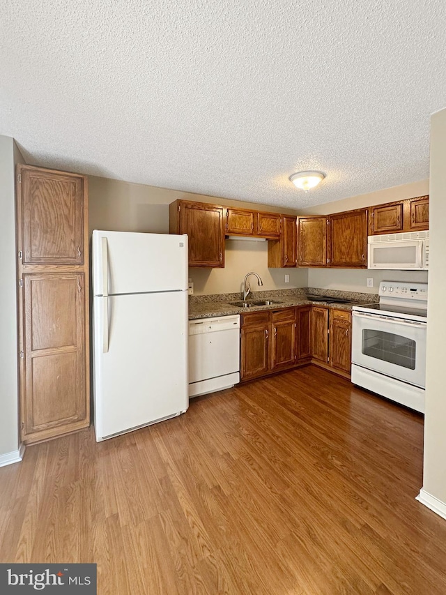7 E Hart St, Winchester, VA 22601 - kitchen featuring white appliances, a sink, wood finished floors, a textured ceiling, and brown cabinets