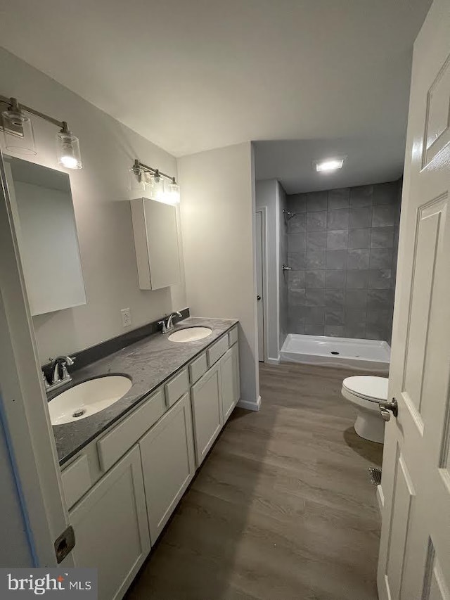 17 Apple Orchard Trl, Berkeley Springs, WV 25411 - bathroom featuring toilet, a tile shower, double vanity, and wood finished floors
