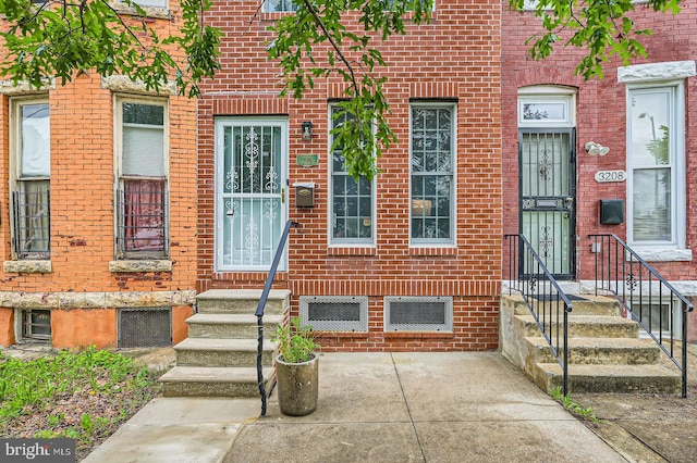 view of exterior entry featuring brick siding