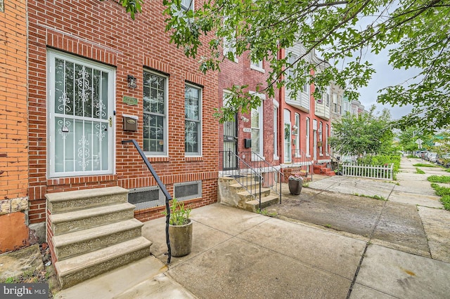 view of exterior entry with brick siding