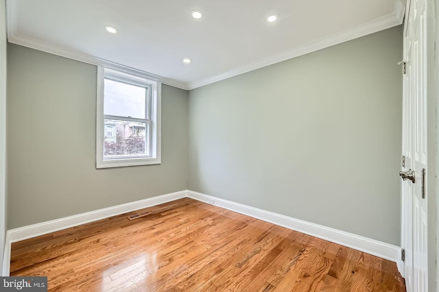 spare room with baseboards, ornamental molding, recessed lighting, and light wood finished floors