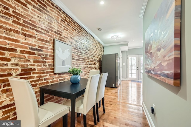 dining room featuring crown molding, baseboards, and light wood-style floors