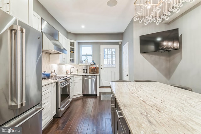 1153 N Hancock St, Philadelphia, PA 19123 - kitchen with appliances with stainless steel finishes, light stone counters, glass insert cabinets, wall chimney range hood, and white cabinets
