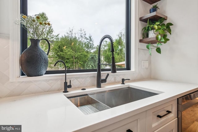 42004 Donnington Pl, Ashburn, VA 20148 - kitchen featuring stainless steel dishwasher, a sink, backsplash, and white cabinetry