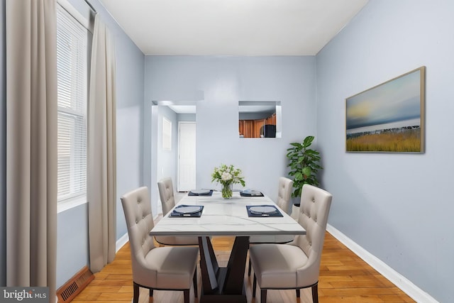 dining room with light wood-style floors and baseboards