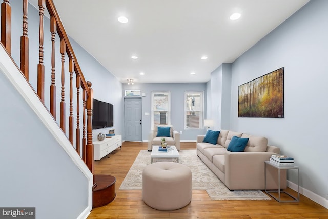 living area featuring light wood-type flooring, stairway, recessed lighting, and baseboards