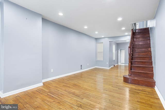 unfurnished living room featuring stairway, light wood-style flooring, baseboards, and recessed lighting