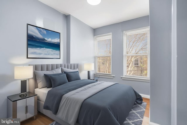 bedroom with wood finished floors and baseboards