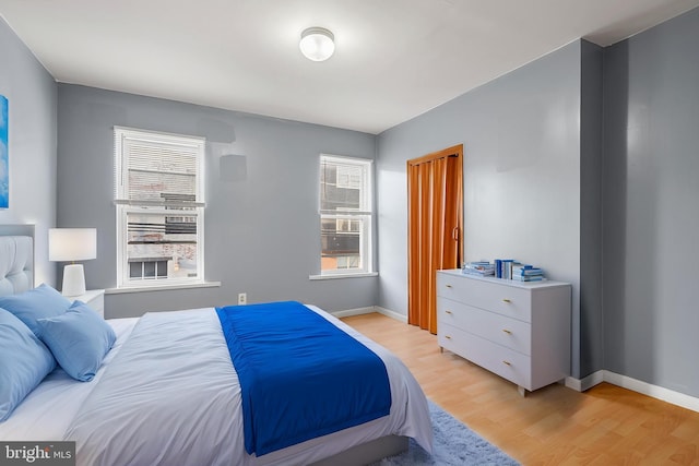 bedroom with light wood finished floors and baseboards