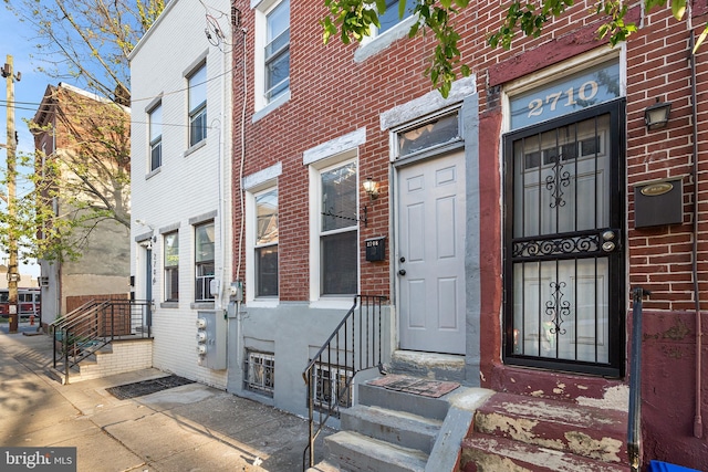 entrance to property featuring brick siding
