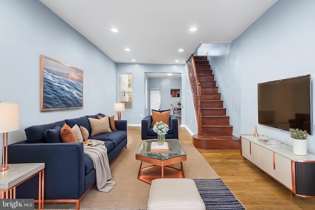 living room with light wood-type flooring, stairs, and recessed lighting