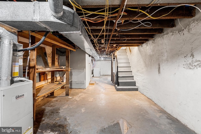 unfinished basement featuring stairway and washer / dryer