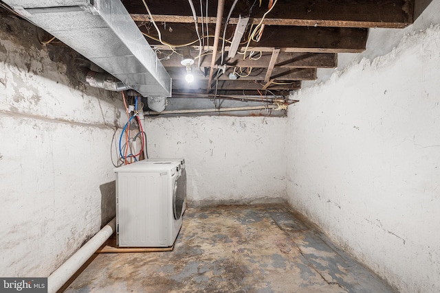 unfinished below grade area featuring washing machine and clothes dryer