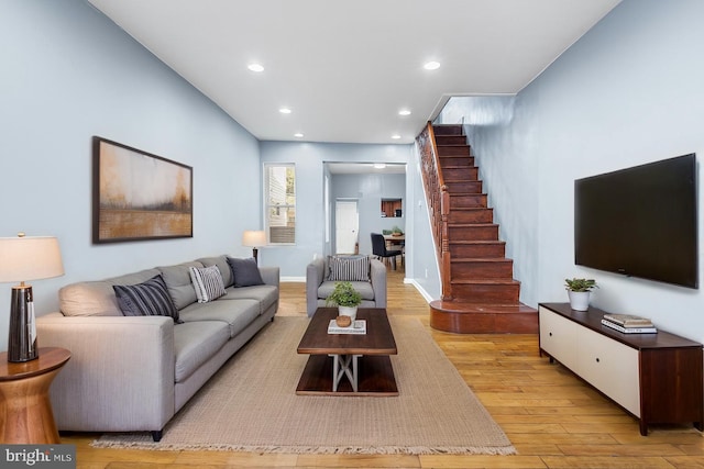 living area with stairs, light wood-style floors, and recessed lighting
