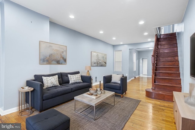living room with stairway, light wood-type flooring, baseboards, and recessed lighting