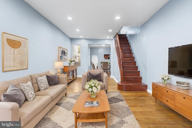 living room featuring stairway, recessed lighting, light wood-style floors, and baseboards