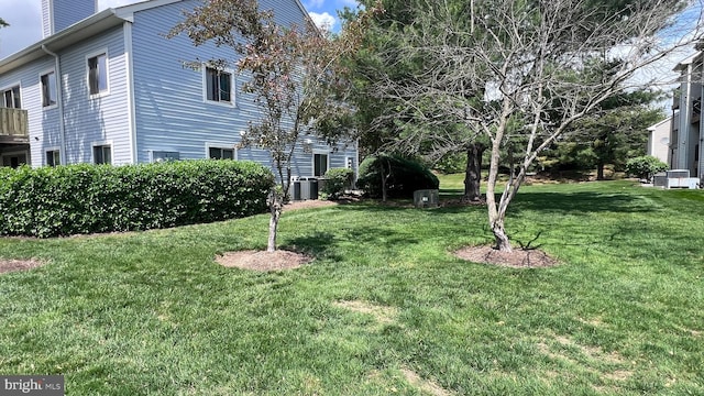 view of green lawn with central air condition unit