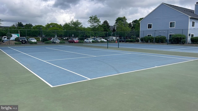 view of tennis court with fence and community basketball court