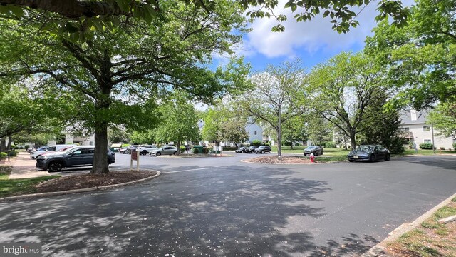 view of asphalt road featuring curbs