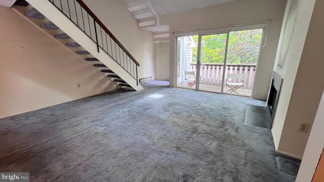 unfurnished living room with carpet, a baseboard heating unit, stairs, and a fireplace