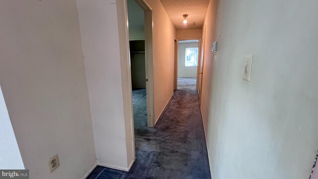 hallway with dark colored carpet