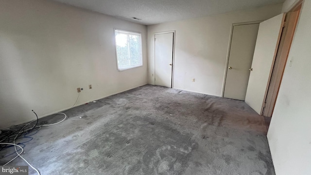 unfurnished bedroom with carpet floors and a textured ceiling