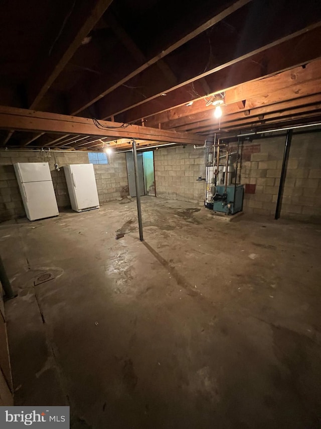 301 Ohio St, Boswell, PA 15531 - unfinished below grade area featuring a heating unit and freestanding refrigerator
