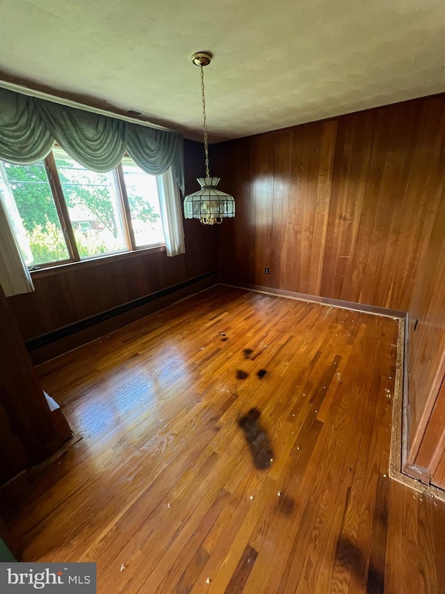 301 Ohio St, Boswell, PA 15531 - unfurnished dining area with wood-type flooring, a chandelier, and wooden walls