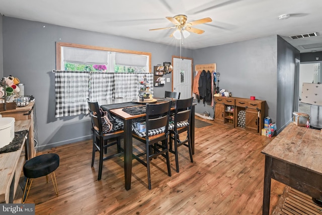 dining area featuring a ceiling fan, wood finished floors, and baseboards
