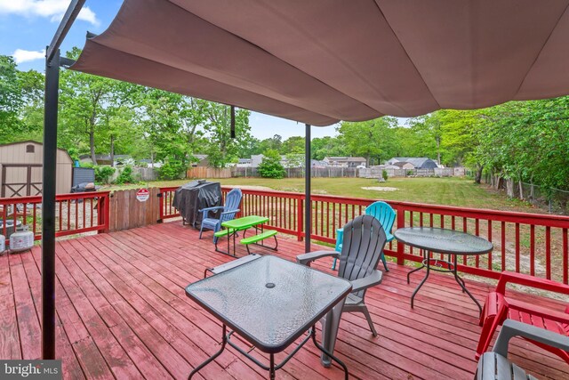 wooden terrace featuring a storage unit and an outdoor structure