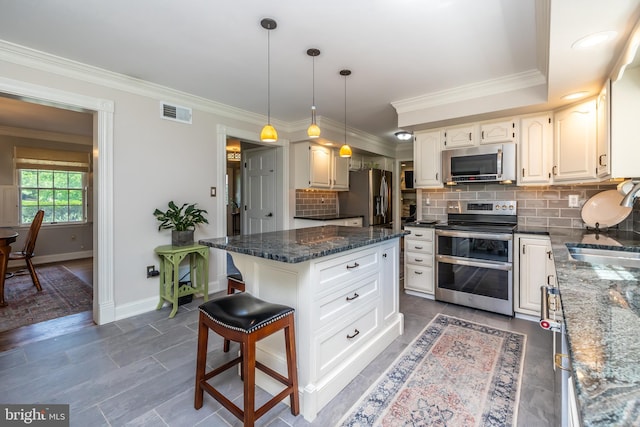 kitchen with stainless steel appliances, baseboards, a sink, backsplash, and dark stone counters