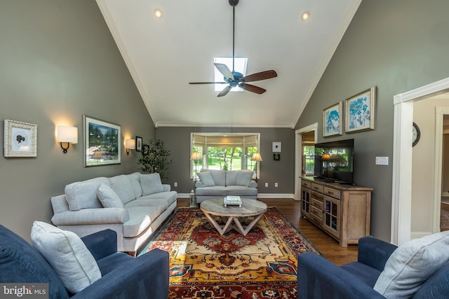 living area with dark wood-type flooring, a ceiling fan, high vaulted ceiling, ornamental molding, and baseboards