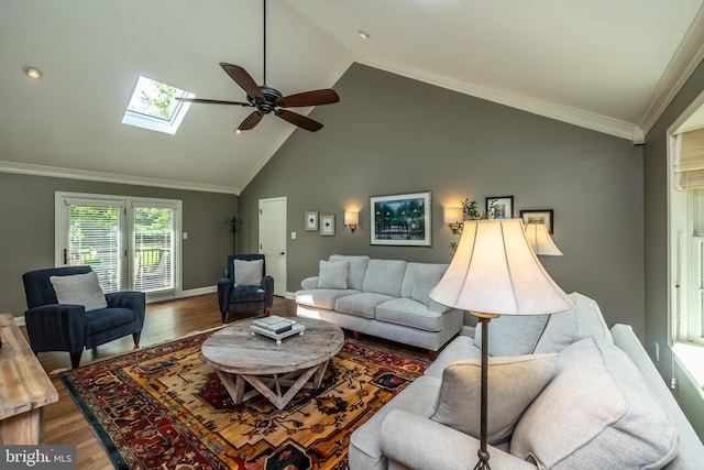 living area with a ceiling fan, wood finished floors, a skylight, crown molding, and high vaulted ceiling