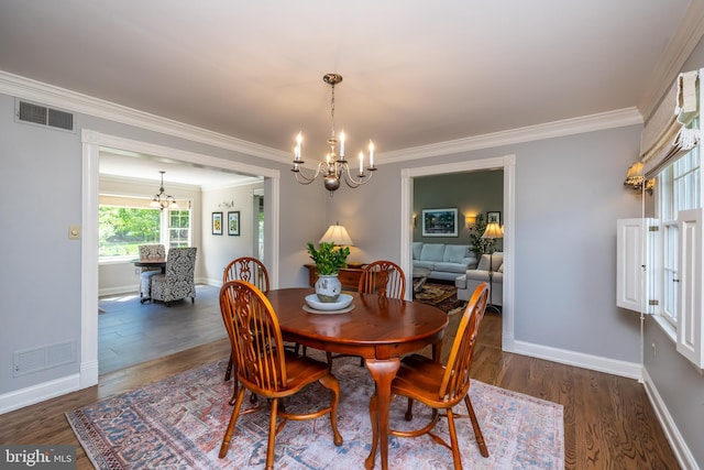 dining room featuring a chandelier, crown molding, dark wood-type flooring, and baseboards