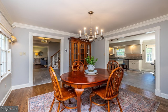 dining room with a chandelier, stairs, baseboards, ornamental molding, and dark wood-type flooring