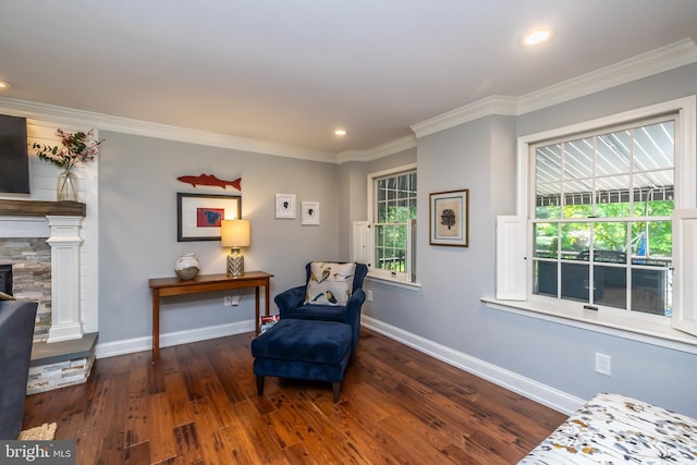 sitting room with wood finished floors, crown molding, baseboards, recessed lighting, and a fireplace