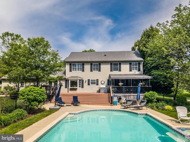 rear view of property featuring a patio, fence, and a wooden deck
