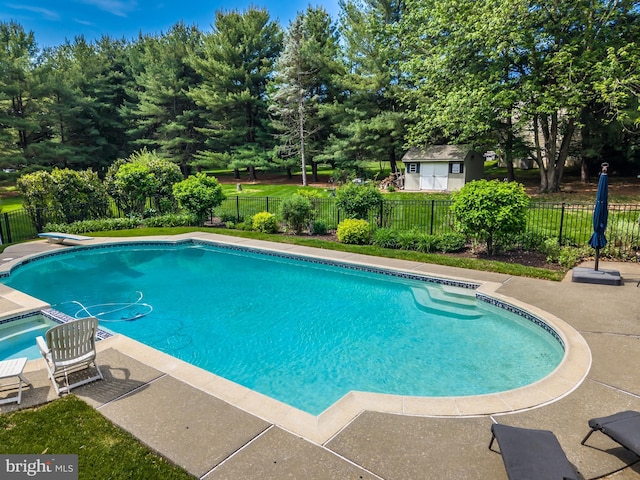 view of pool featuring fence, a patio area, and a diving board