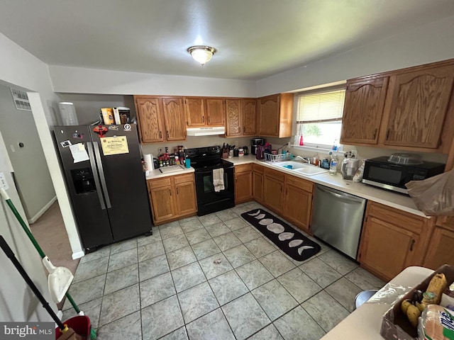 168 Garden Ave, Browns Mills, NJ 08015 - kitchen with black appliances, under cabinet range hood, a sink, light countertops, and brown cabinets