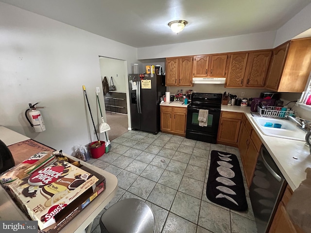 168 Garden Ave, Browns Mills, NJ 08015 - kitchen with black appliances, under cabinet range hood, a sink, light countertops, and brown cabinetry