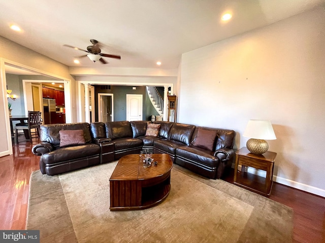 living area with ceiling fan, wood finished floors, baseboards, recessed lighting, and stairway