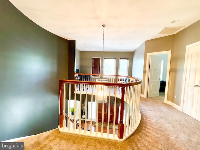 hall featuring an upstairs landing, carpet flooring, and baseboards