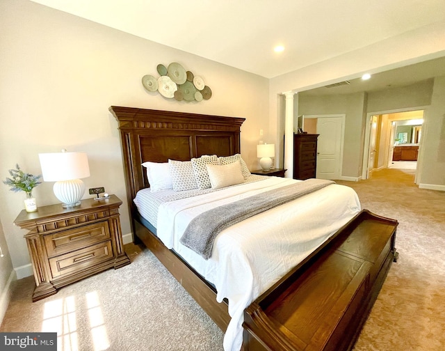 bedroom featuring light carpet, baseboards, decorative columns, and recessed lighting